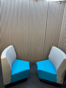 Two-piece curved fabric seating modules in grey and teal blue.