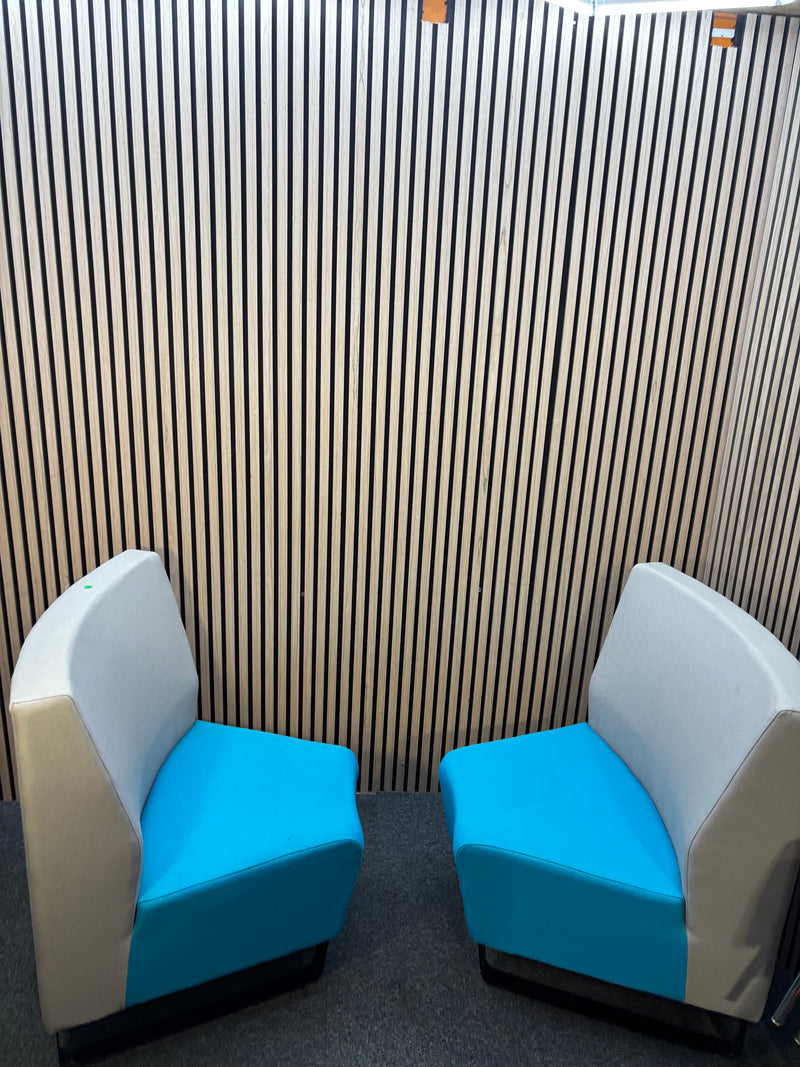 Two-piece curved fabric seating modules in grey and teal blue.