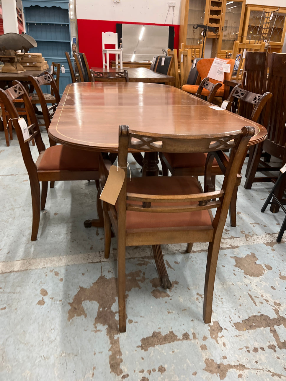 Oval shaped mahogany extendable table on castors with matching  2 carver and 4 dining chairs with red fabric seat 2125