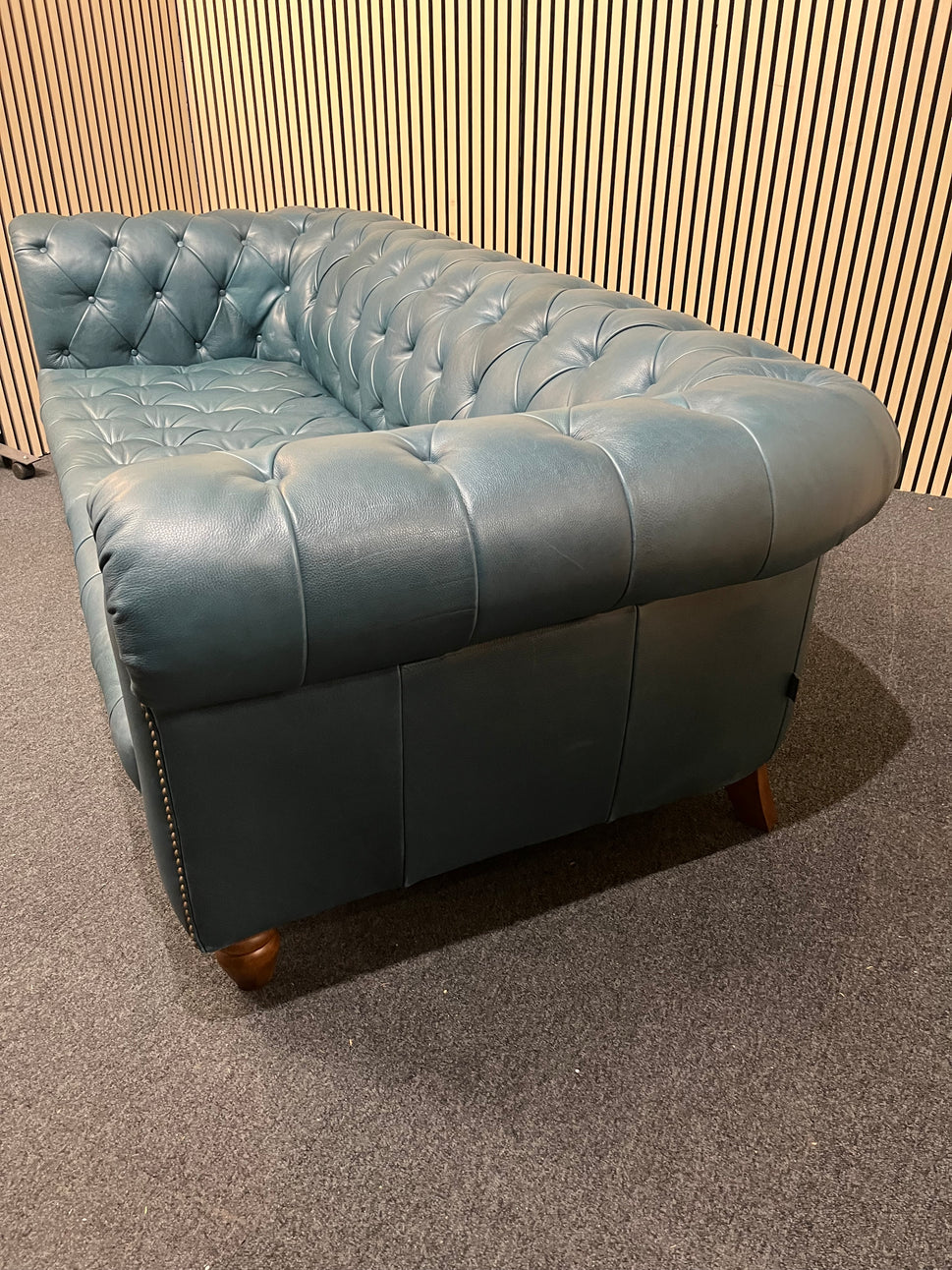 3 seater Chesterfield-style leather sofa in deep teal leather with tufted upholstery, rolled arms, and wooden legs accented by brass nailhead trim (width 230 cm) 1425