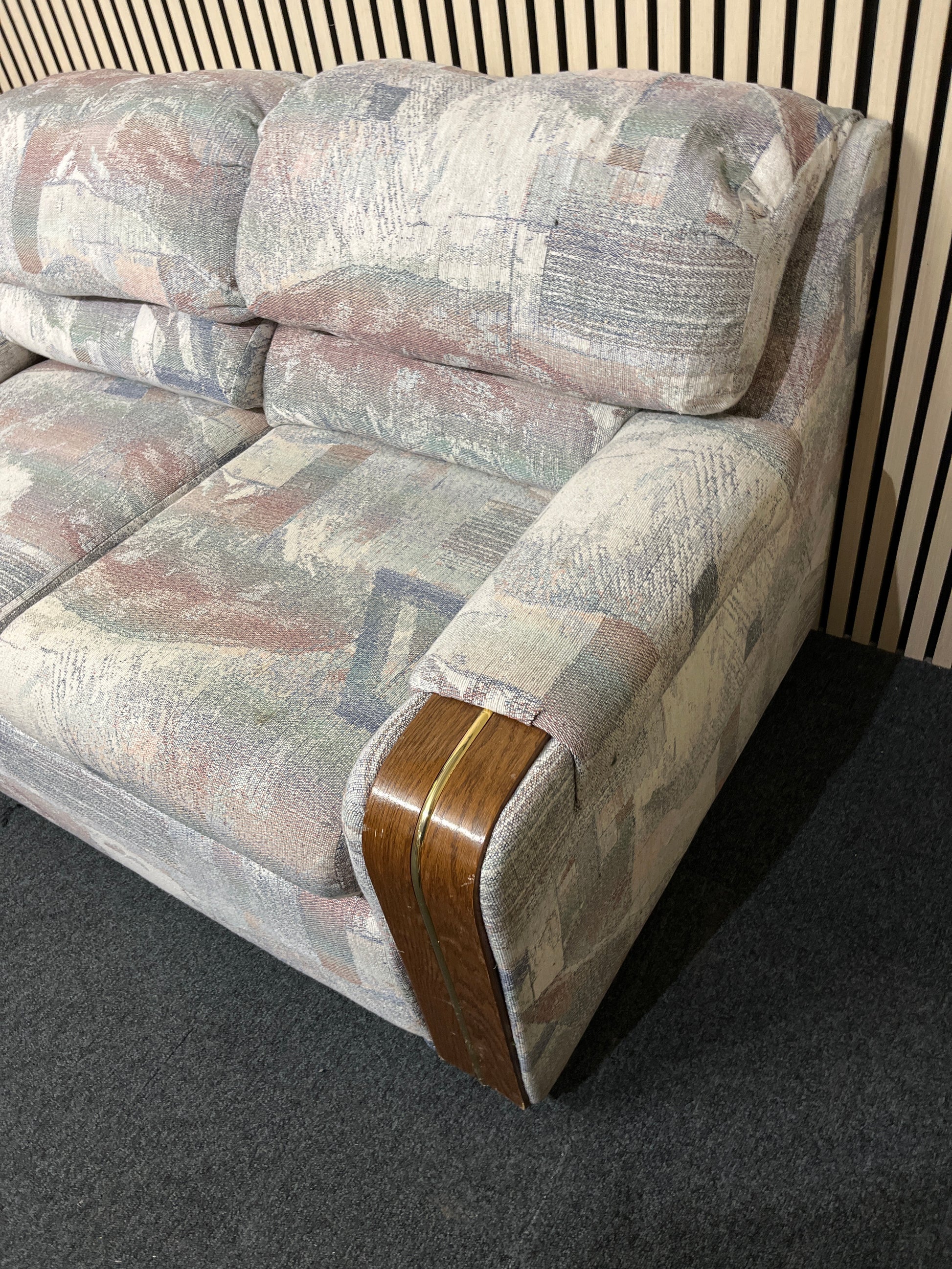 Patterned two-seater sofa with wooden arm accents
