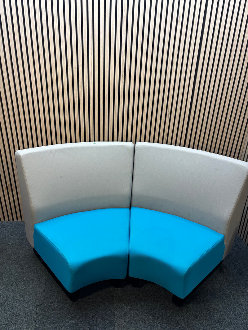 Two-piece curved fabric seating modules in grey and teal blue.