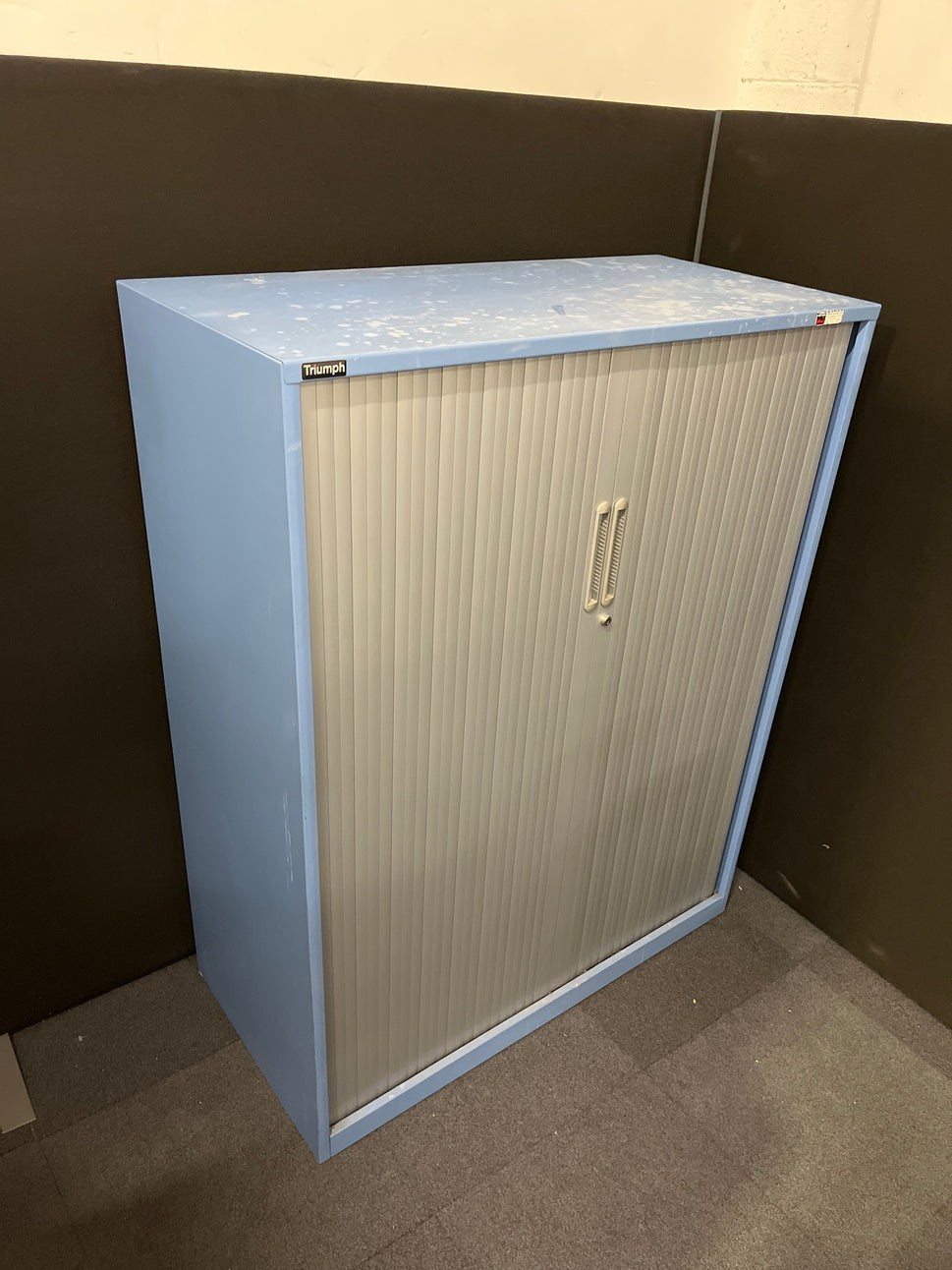 Secondhand Triumph Blue metal framed, silver plastic sliding door tambour  with 2 no. internal shelves and 1 no. key 1000Wx1290Hx475D