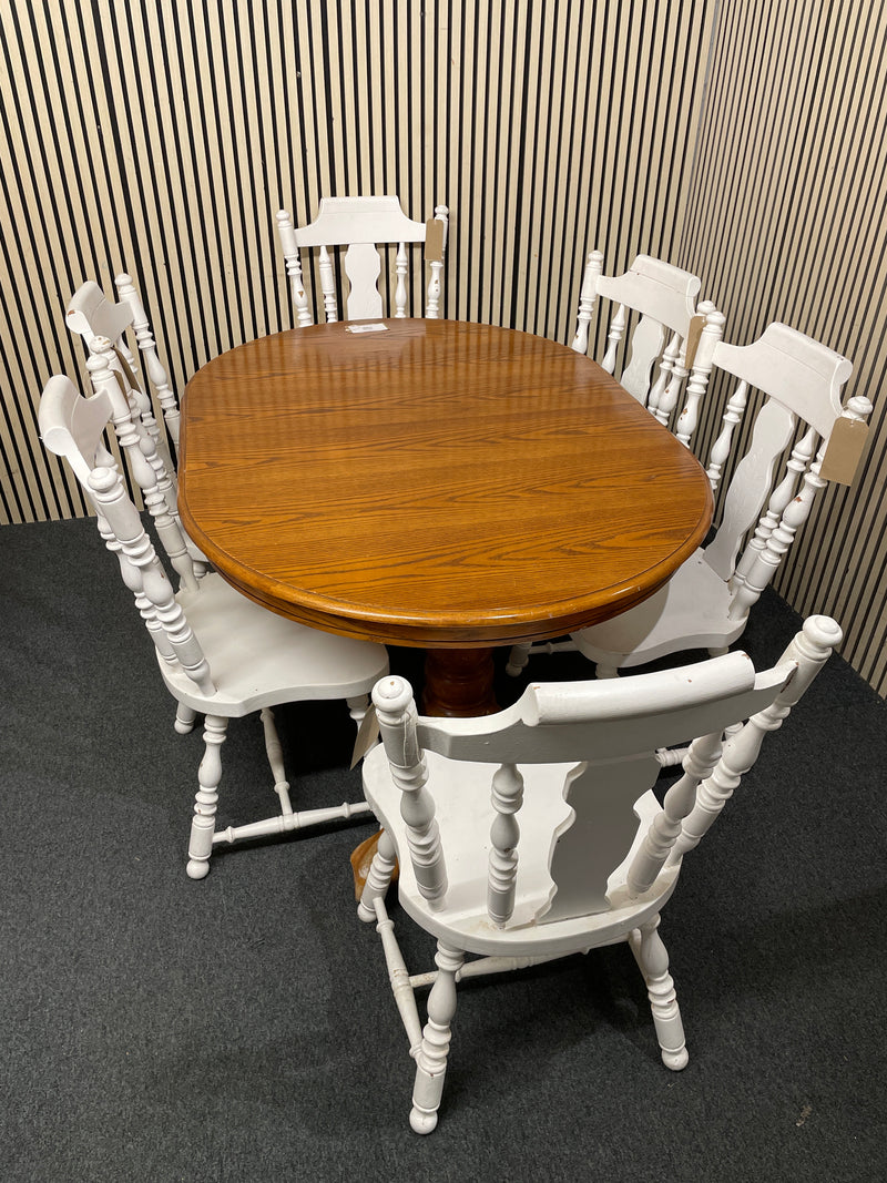 Oval wood dining table with six white spindle back chairs.  44515
