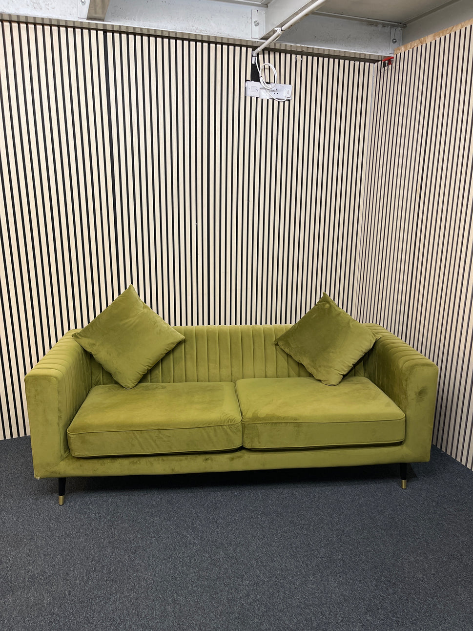 Modern olive green velvet sofa with vertical channel tufting, 2 seat cushions and slim black legs assencted with gold tips( W x 197 L x 81 H x 73 cm)