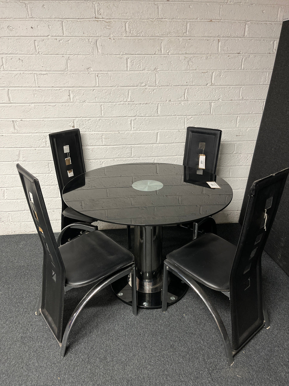 Black glass circular kitchen table (radius x 1060 mm), central base with 4 no. high back black leatherette and chrome dining chairs  1225