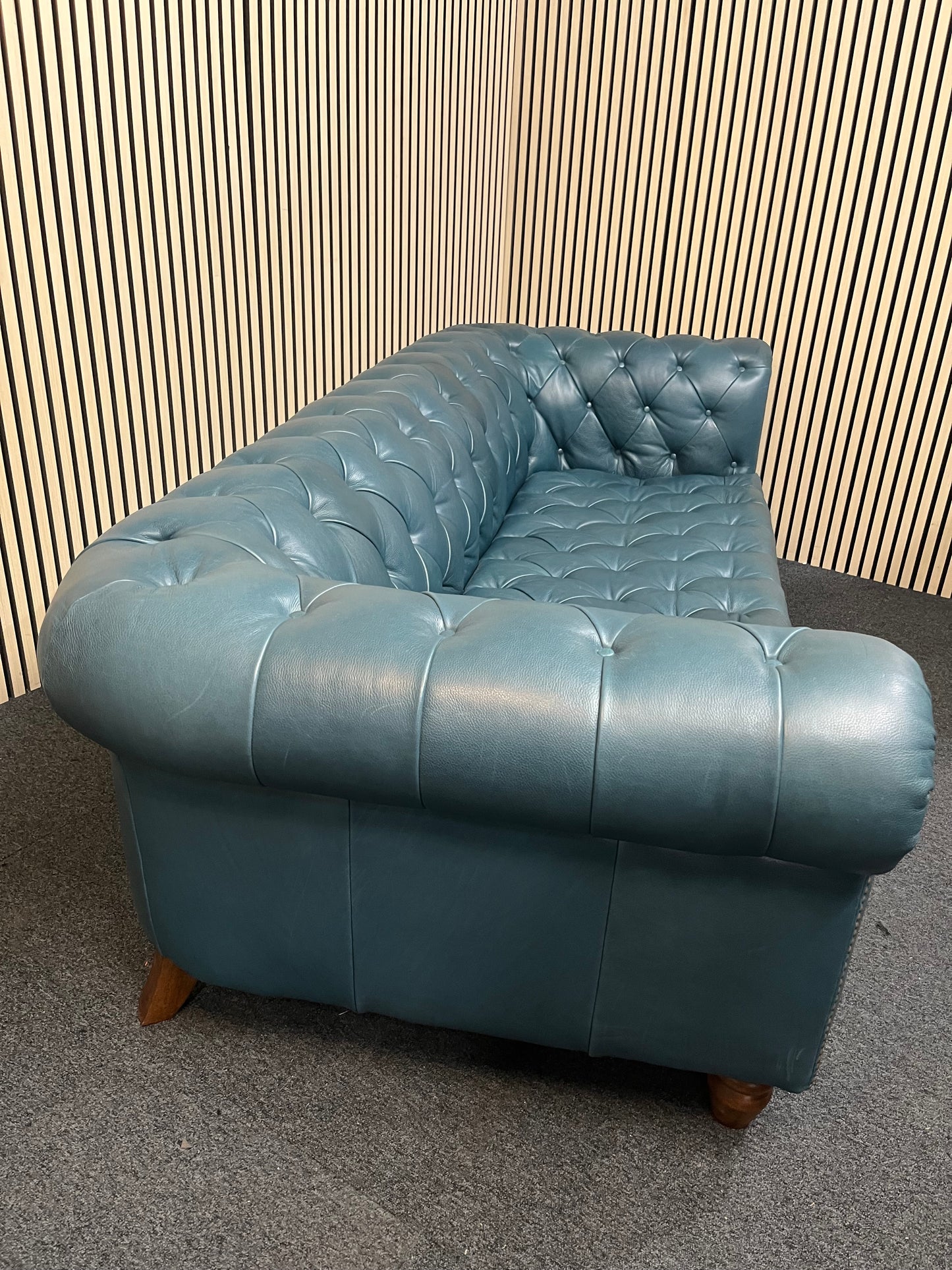 3 seater Chesterfield-style leather sofa in deep teal leather with tufted upholstery, rolled arms, and wooden legs accented by brass nailhead trim (width 230 cm) 1425