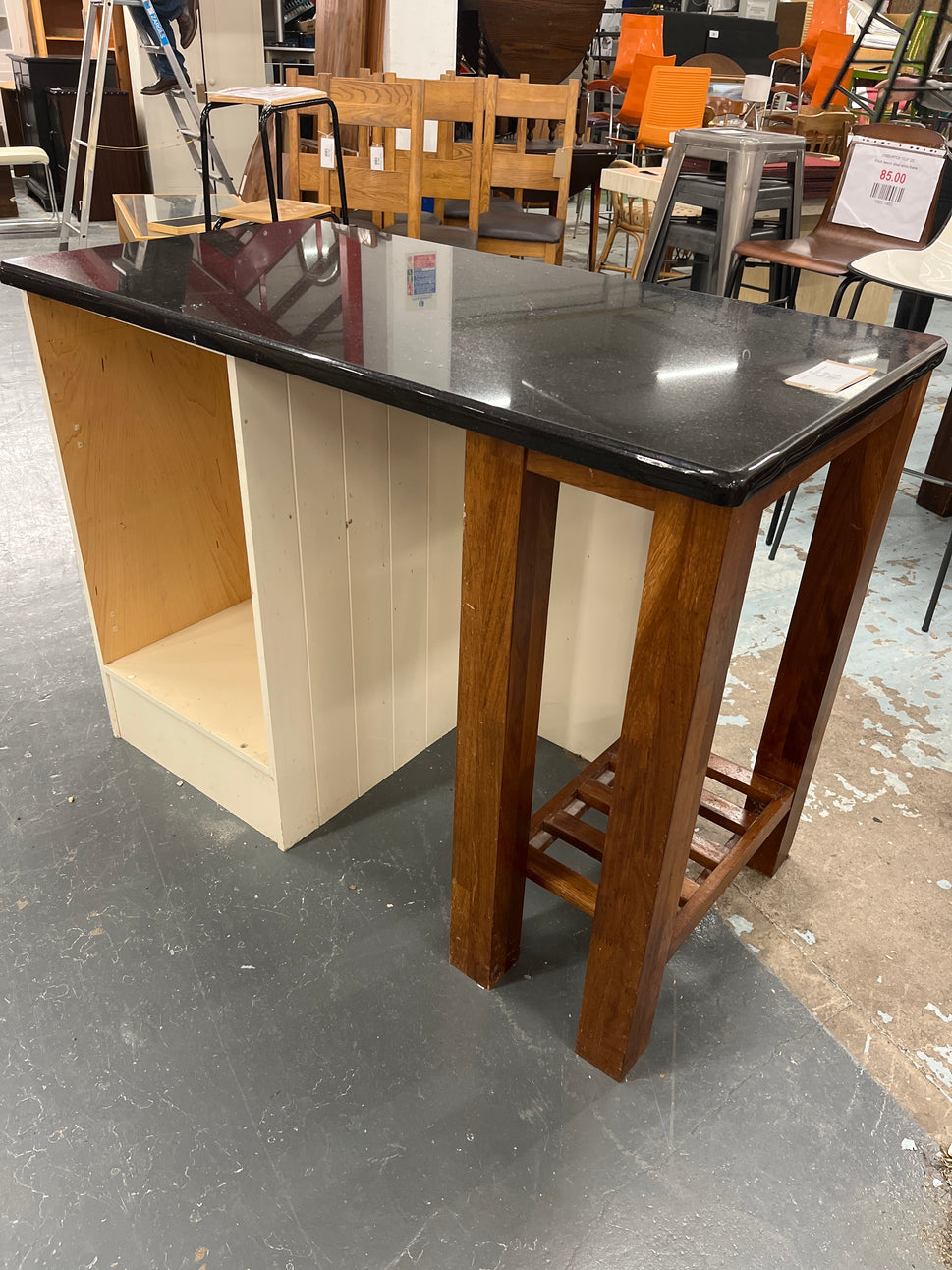 Granite kitchen island with cream frame and dark wood shelf unit  2125
