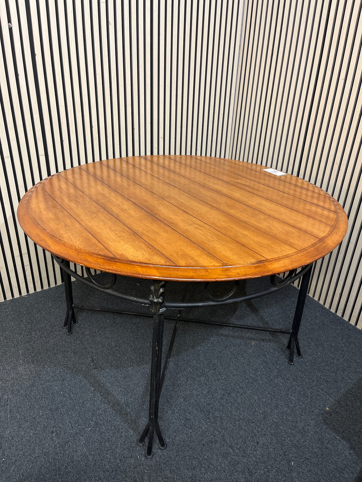 Round slatted wood top with decorative black metal base.(125 cm diameter)  44256
