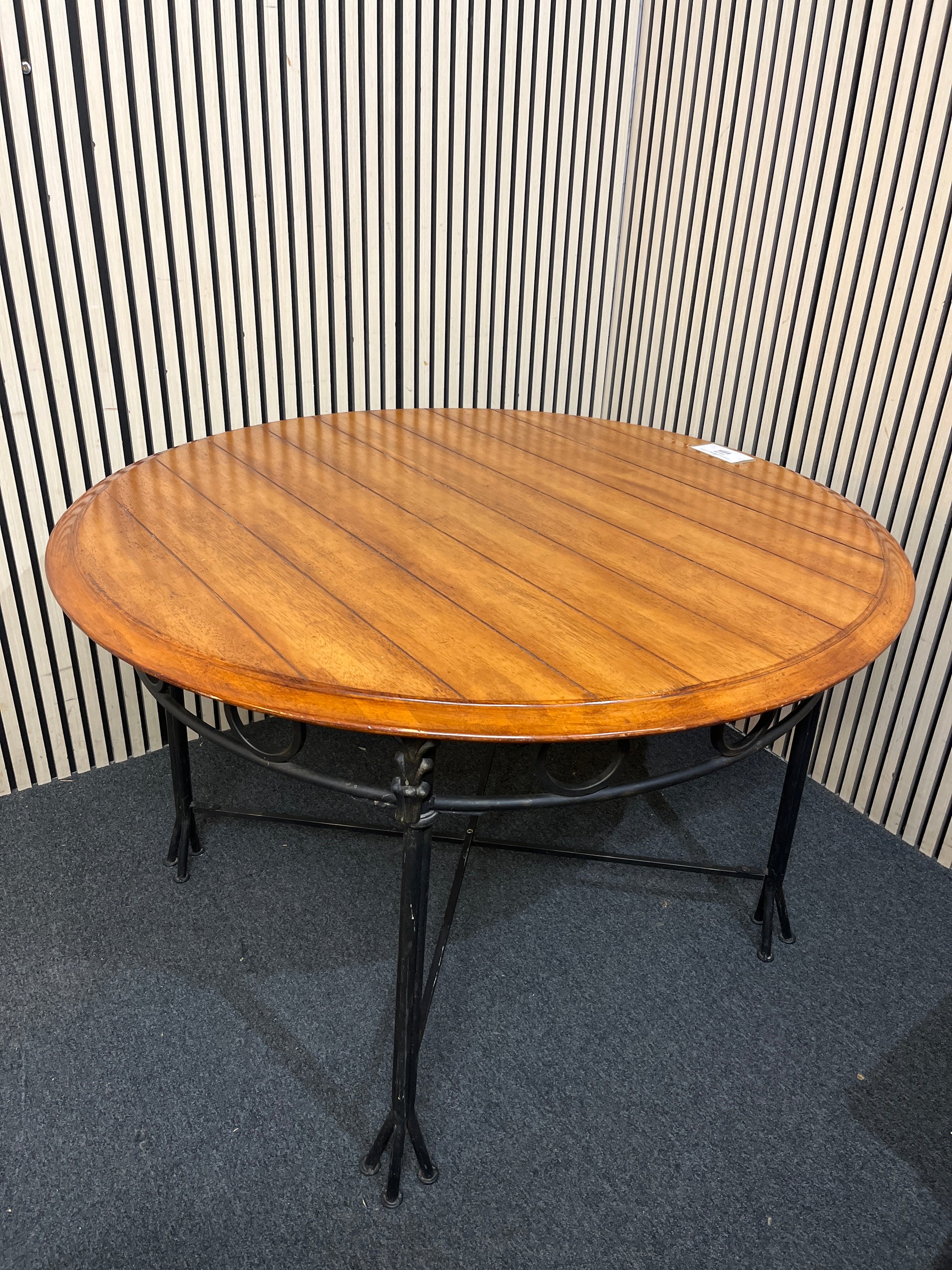 Round slatted wood top with decorative black metal base.(125 cm diameter)  44256
