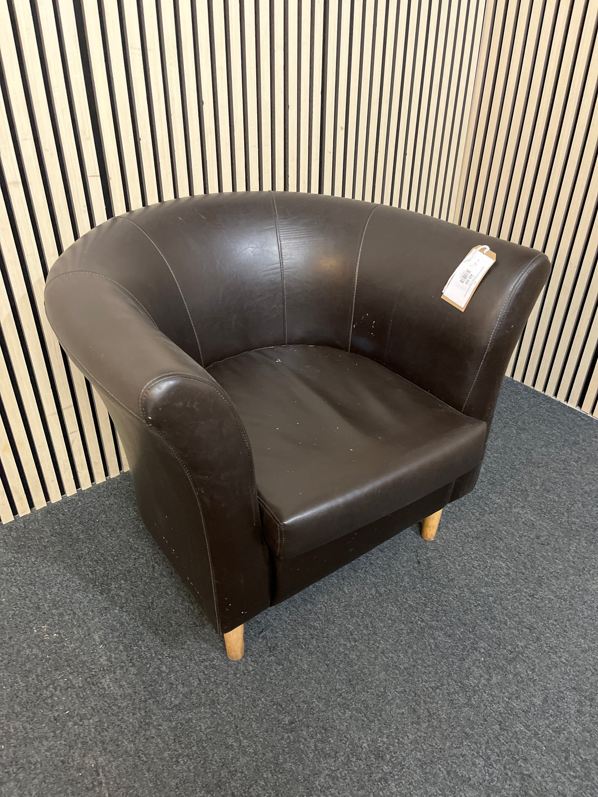 Modern curved black faux leather armchair in good condition.  44275
