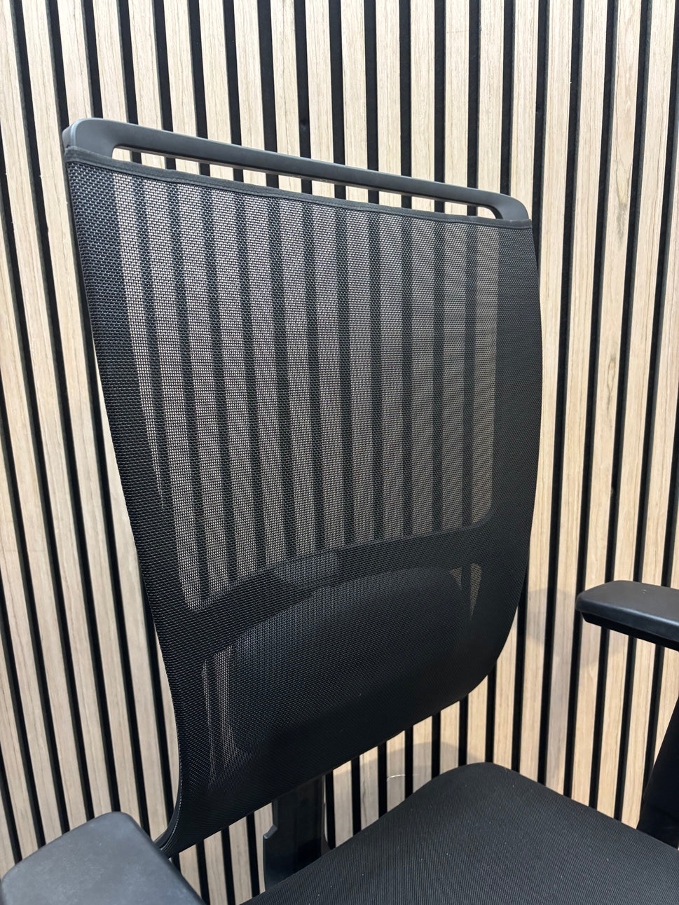Black mesh back swivel chair with adjustable arms and 5 star swivel base