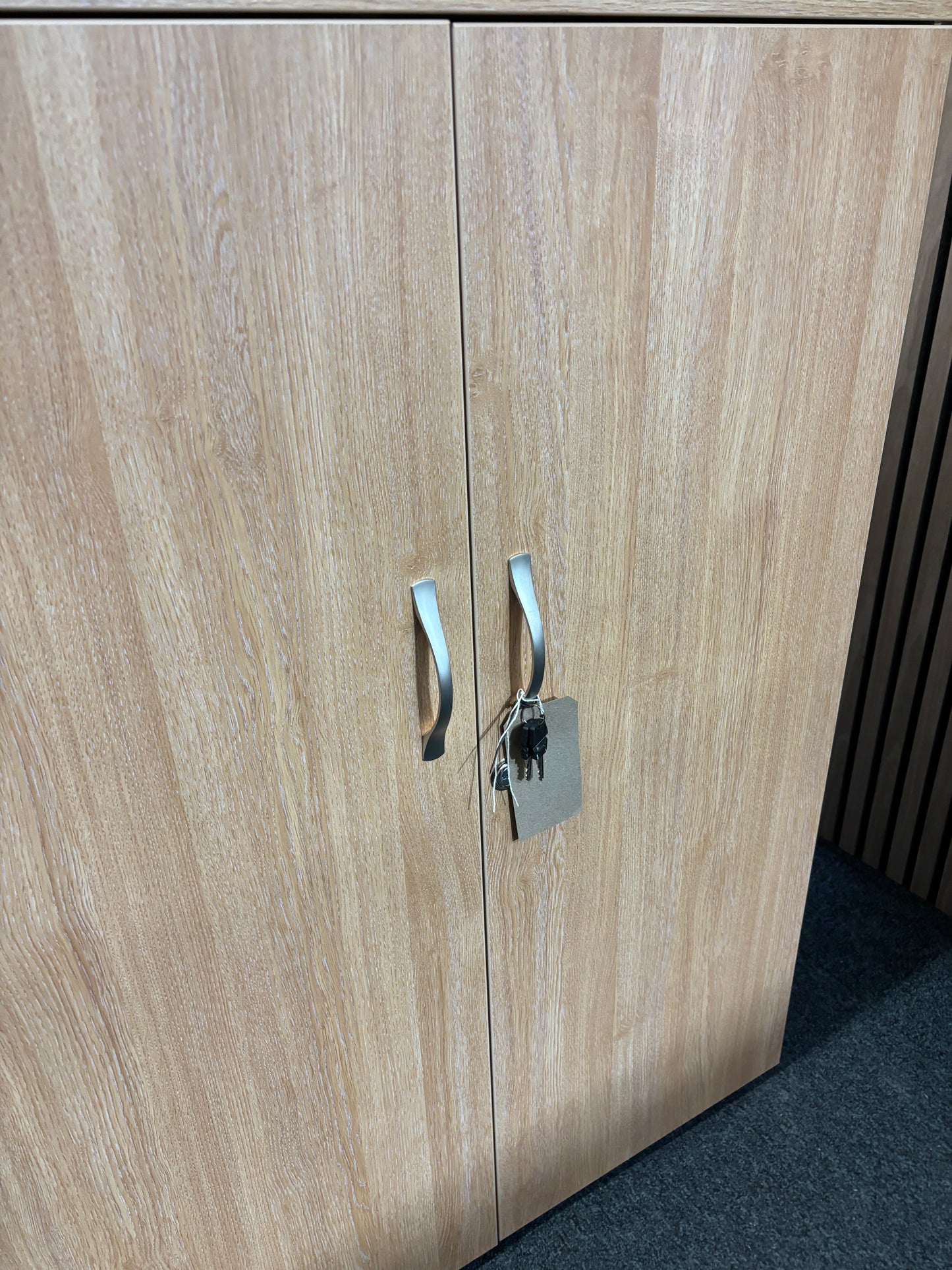 Universal 2 door storage unit in oak laminate with 2 no. internal shelves and key 1090Hx470Dx800W