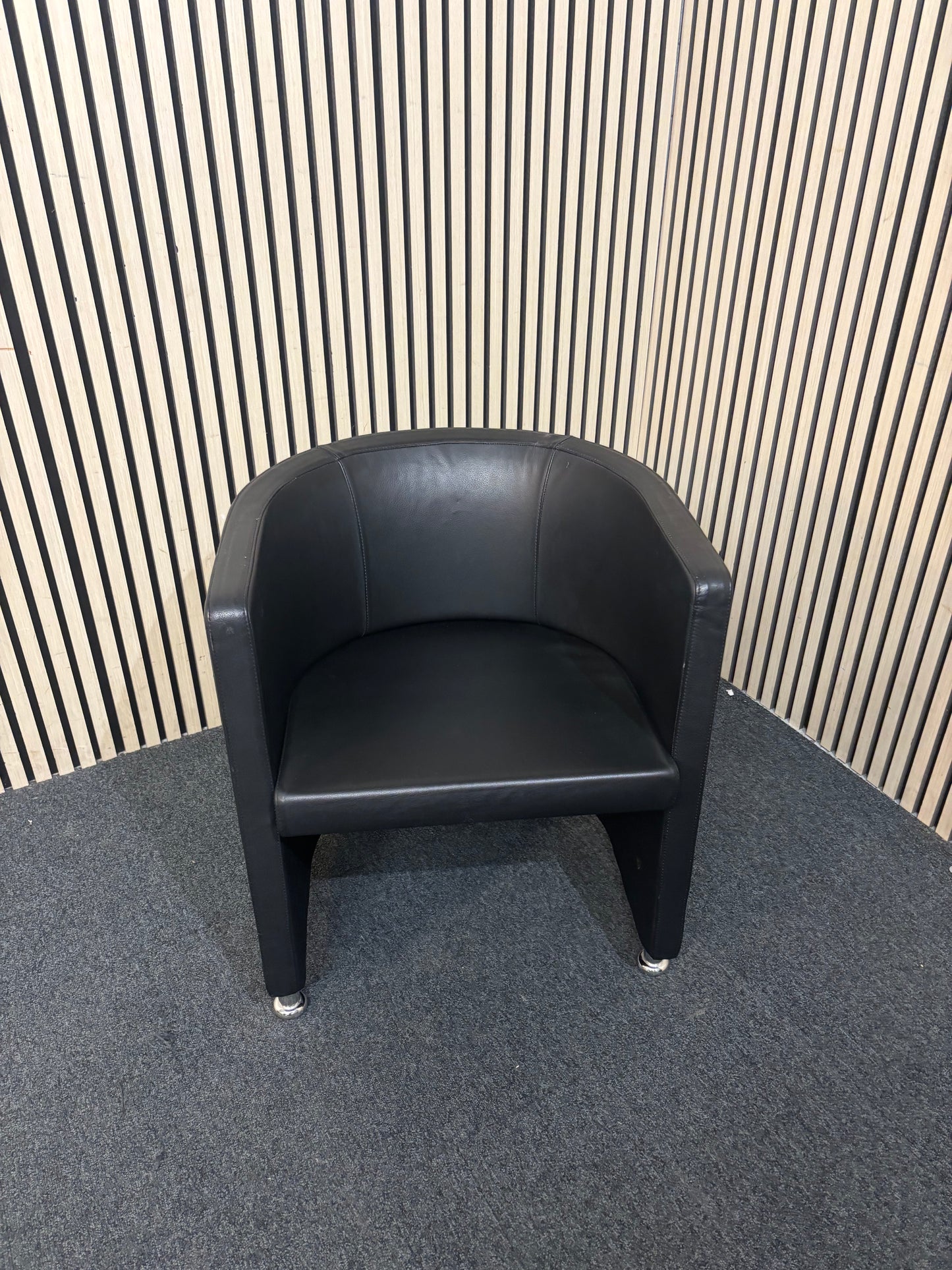 Dark leather curved back tub chair