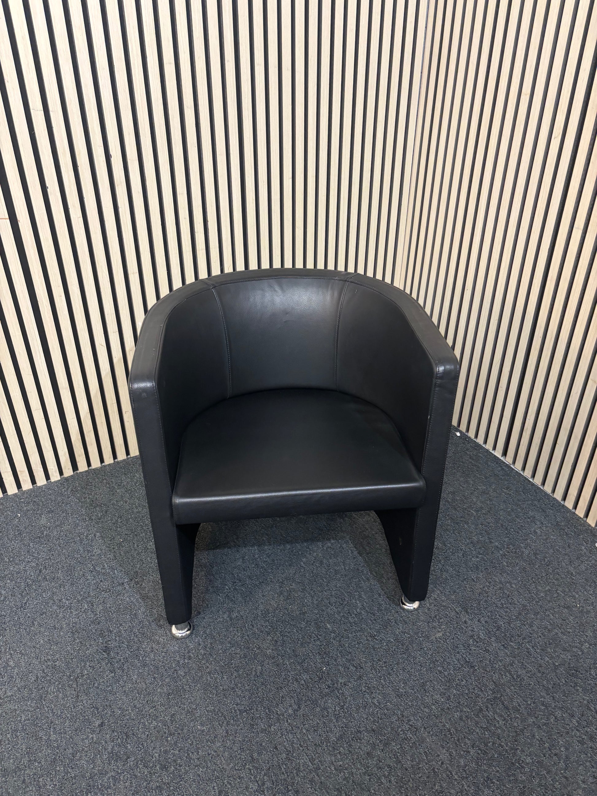 Dark leather curved back tub chair