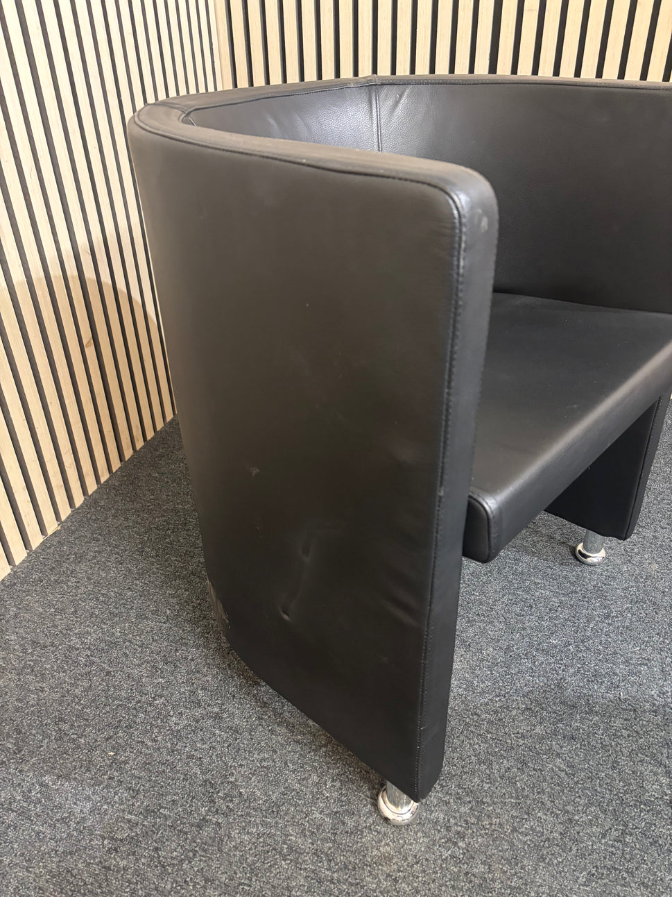 Dark leather curved back tub chair