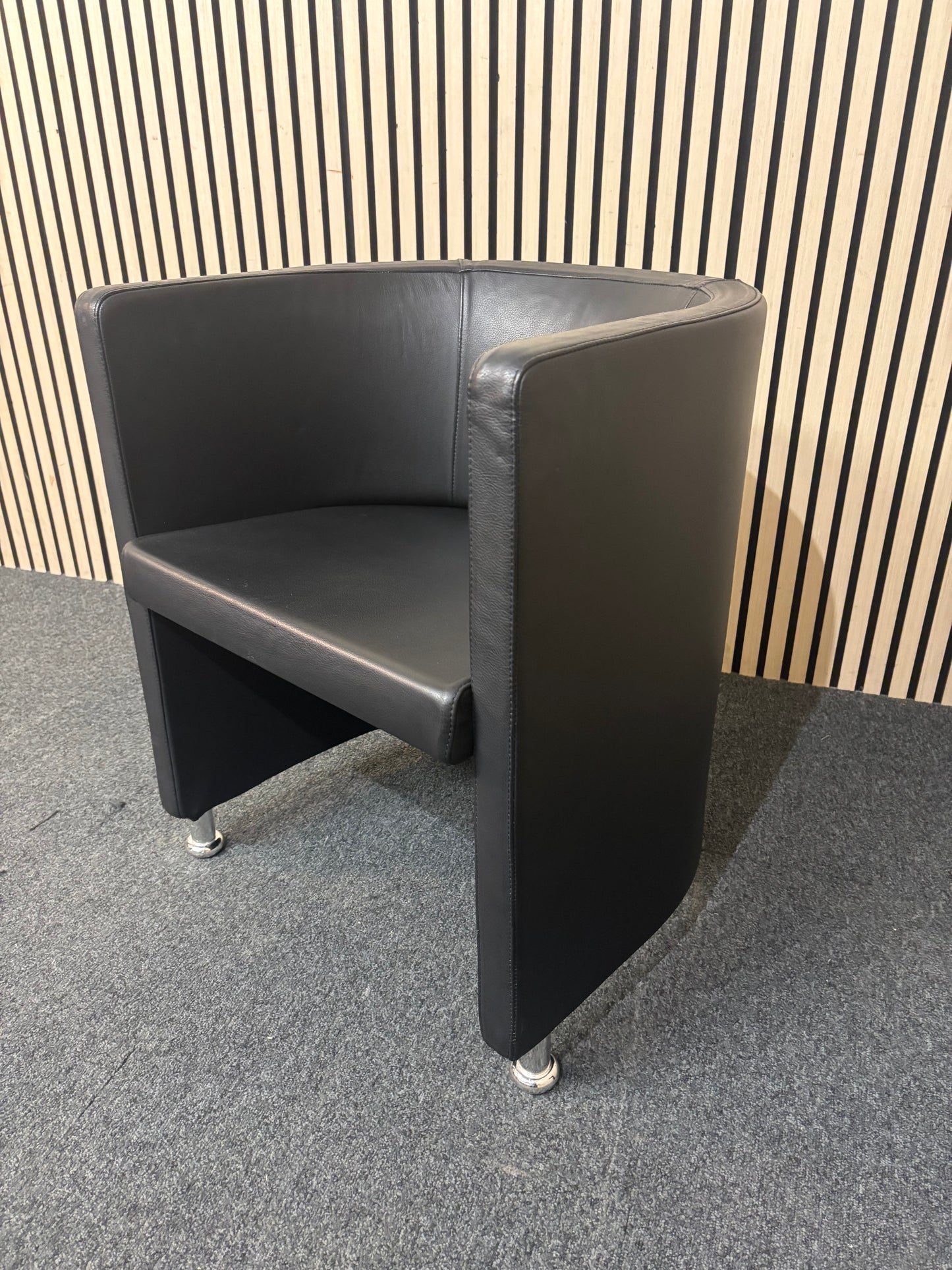 Dark leather curved back tub chair