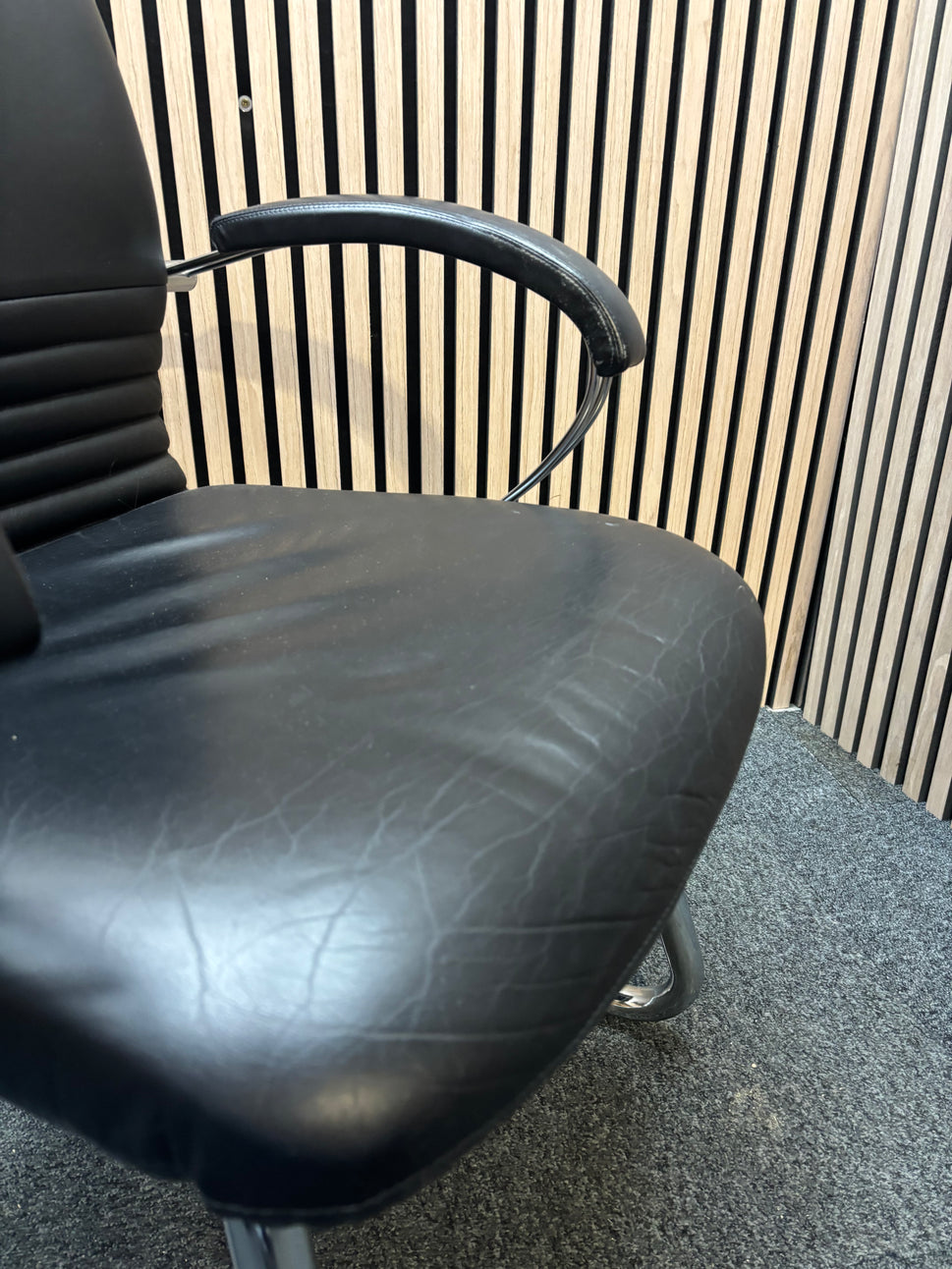 Black leatherette solid metal framed meeting chair with arms