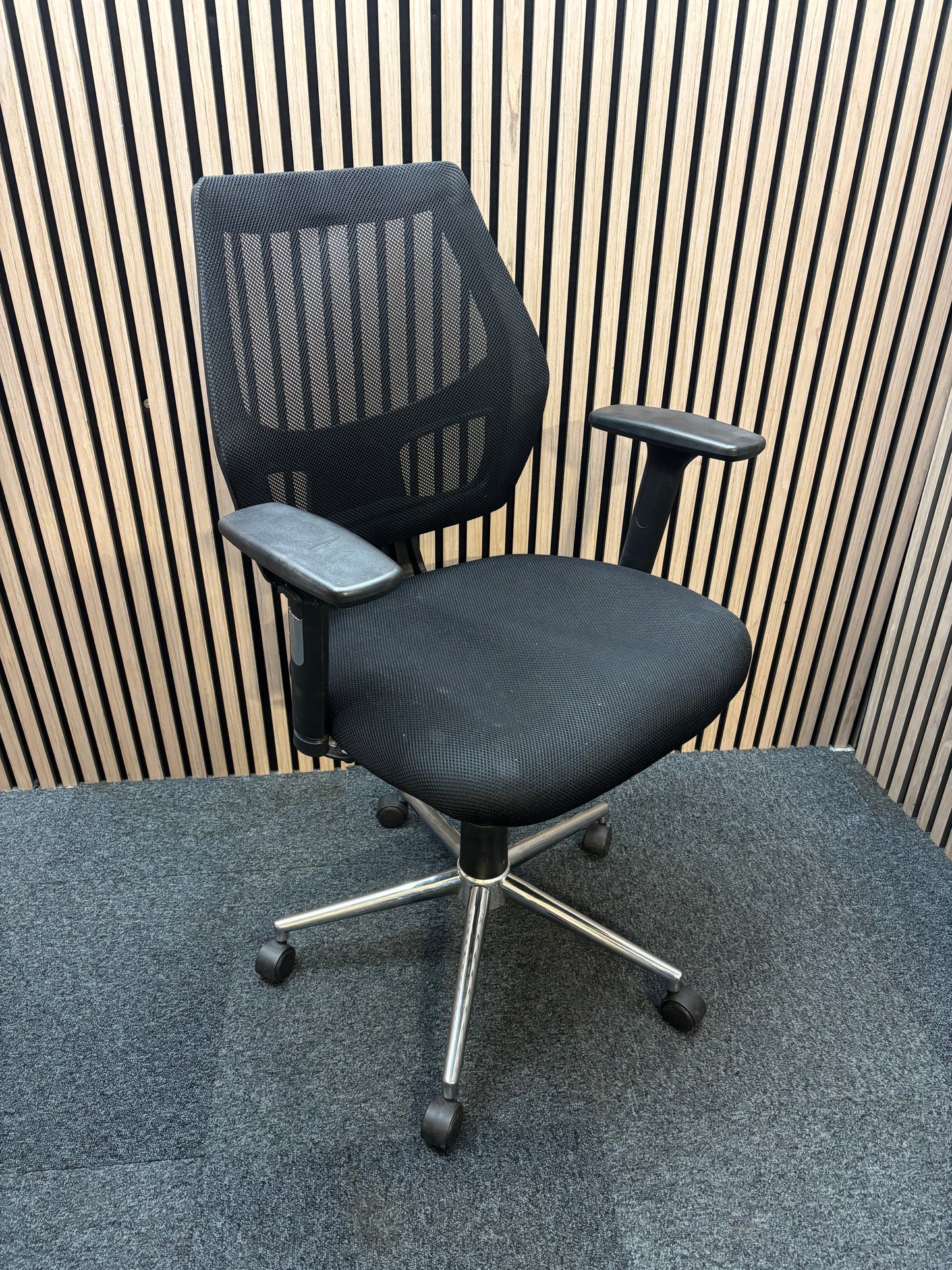 Black mesh back second hand swivel chair with adjustable arms and black fabric seat