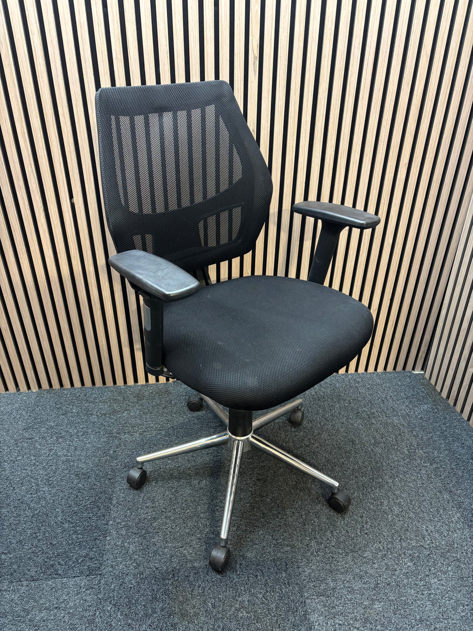 Black mesh back second hand swivel chair with adjustable arms and black fabric seat