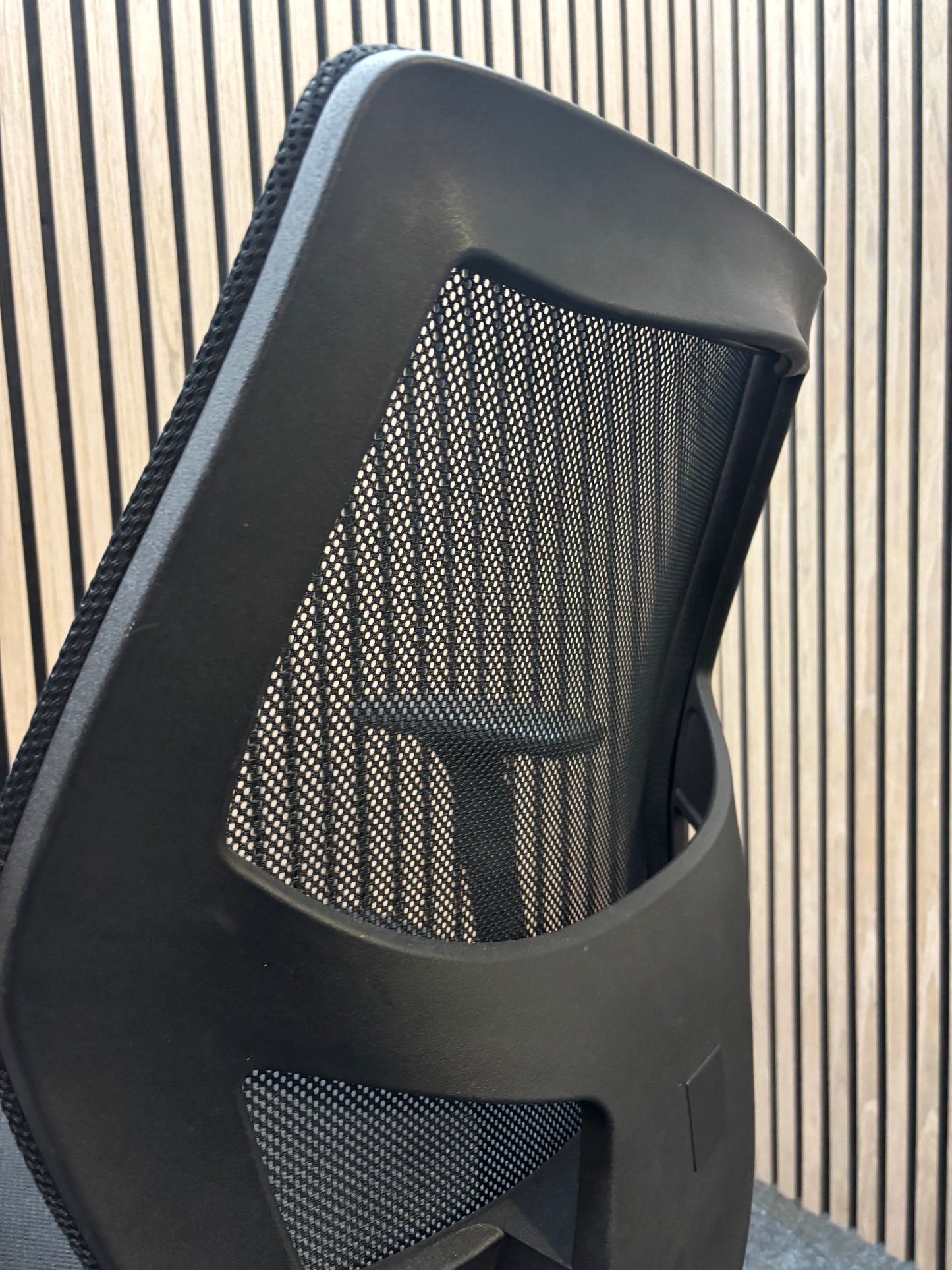 Black mesh back second hand swivel chair with adjustable arms and black fabric seat