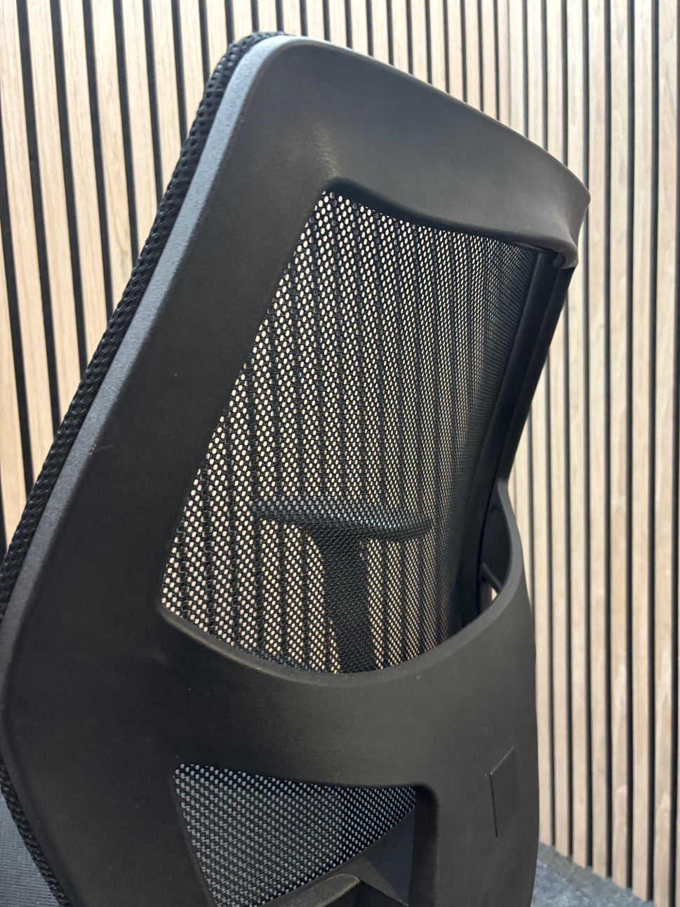 Black mesh back second hand swivel chair with adjustable arms and black fabric seat