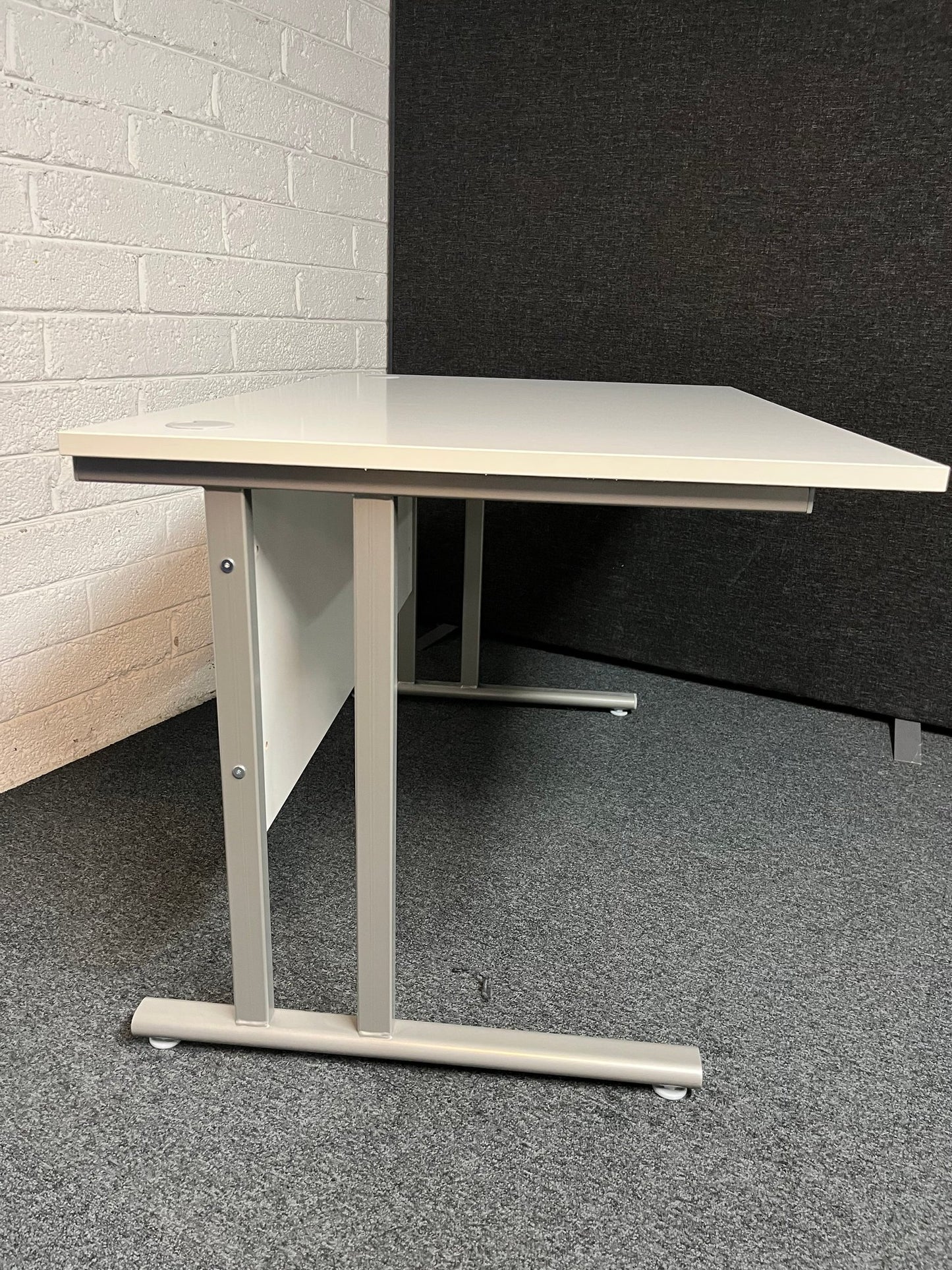SECONDHAND 1200Lx800Dx720H White cantilever desk with silver metal frame and white modestly panel. IN EXCELLENT CONDITION. Price inclusive of VAT