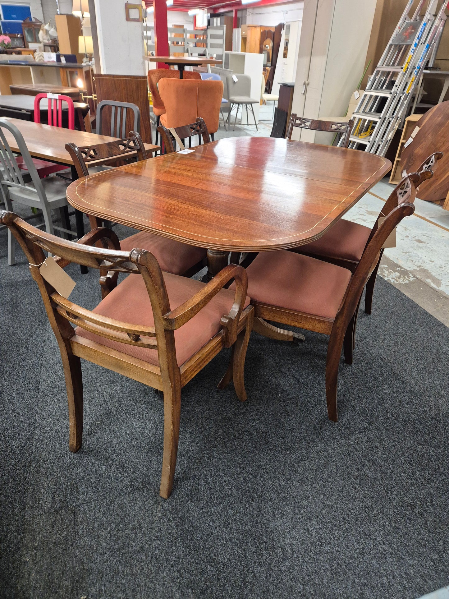 Oval shaped mahogany extendable table on castors with matching  2 carver and 4 dining chairs with red fabric seat 2125