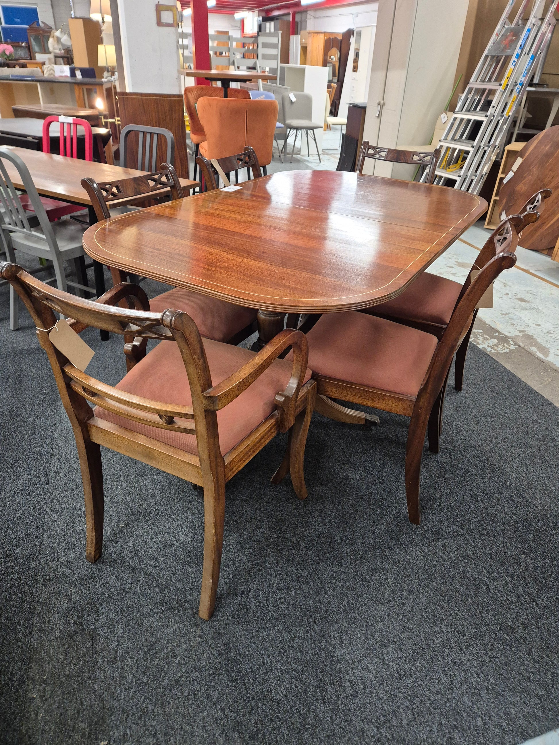 Oval shaped mahogany extendable table on castors with matching  2 carver and 4 dining chairs with red fabric seat 2125
