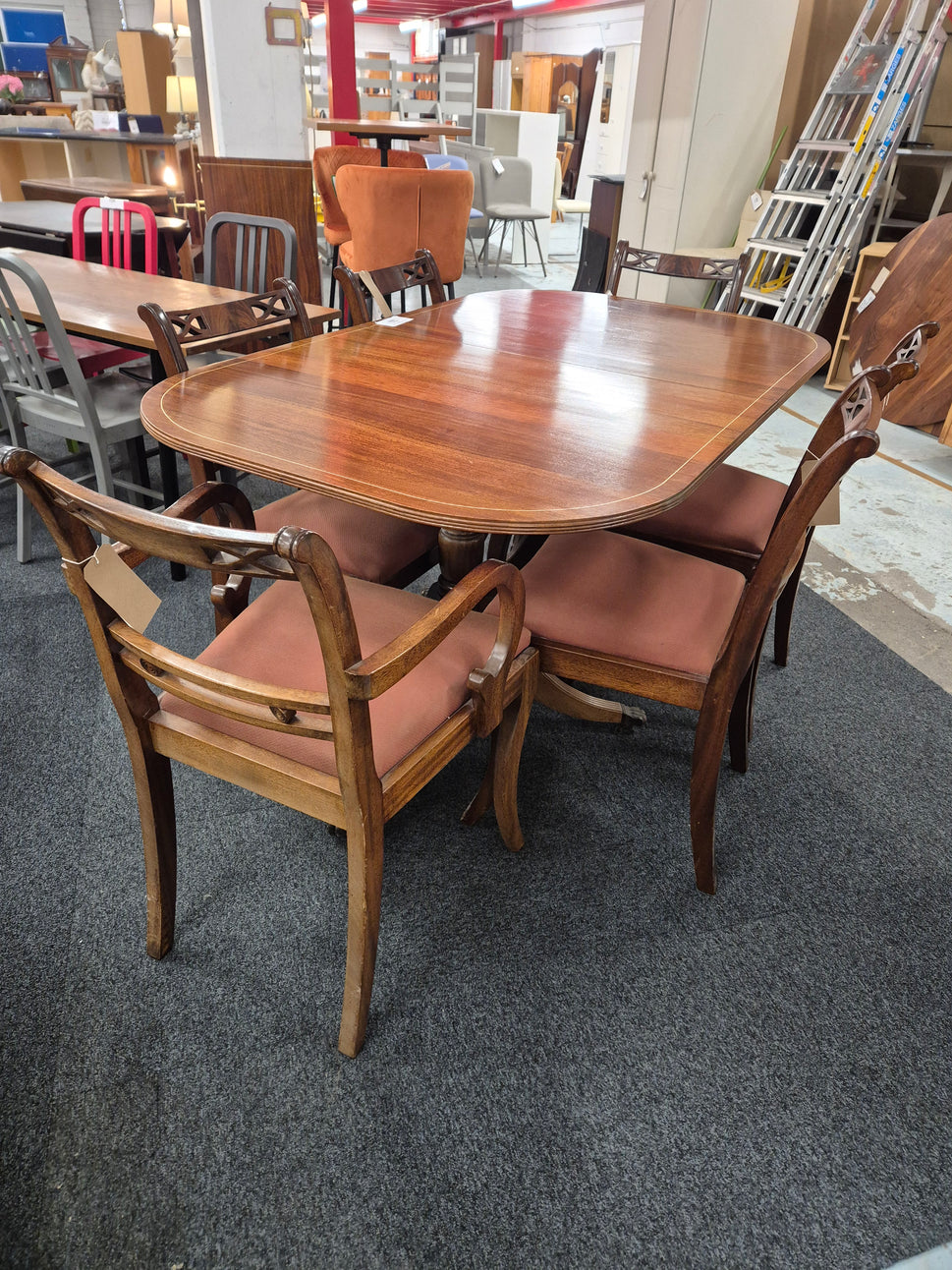 Oval shaped mahogany extendable table on castors with matching  2 carver and 4 dining chairs with red fabric seat 2125