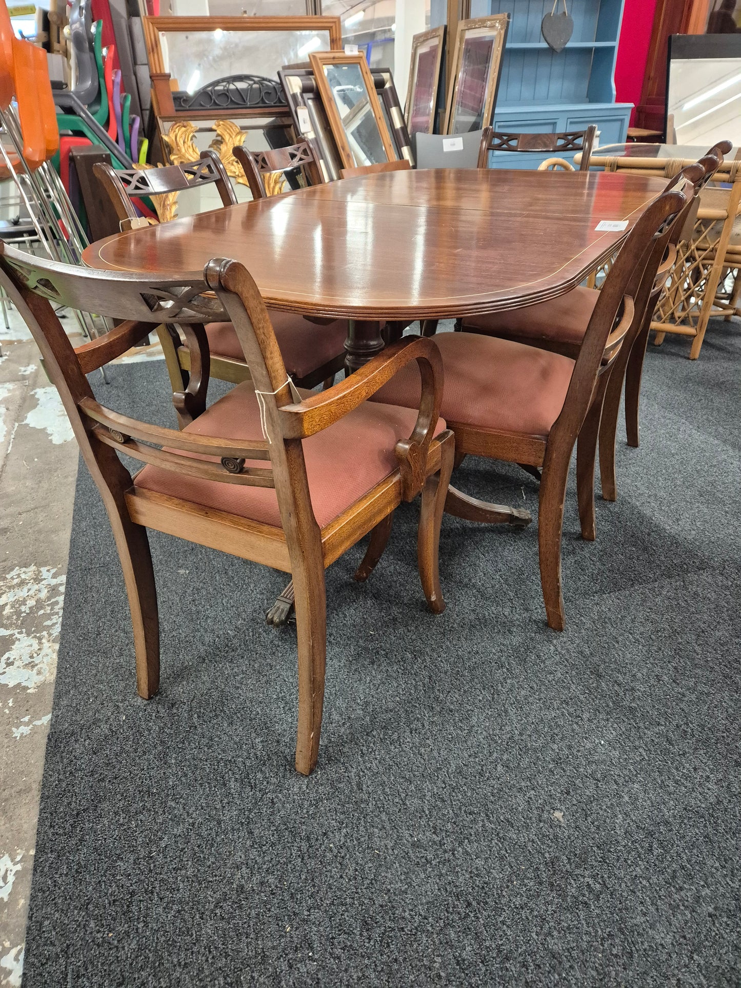 Oval shaped mahogany extendable table on castors with matching  2 carver and 4 dining chairs with red fabric seat 2125